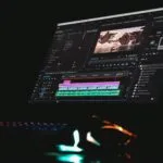 black laptop computer turned on displaying music player